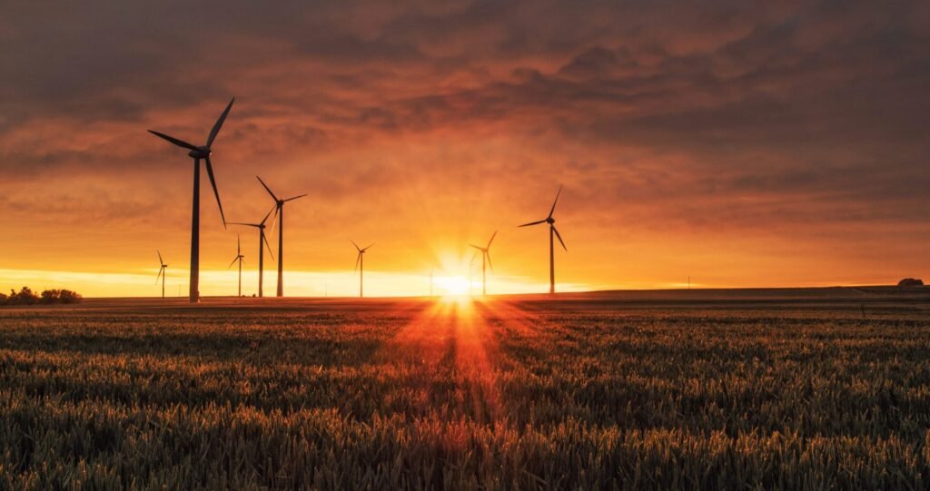 A beautiful sunset with wind generating windmills silhouetted against the orange sky