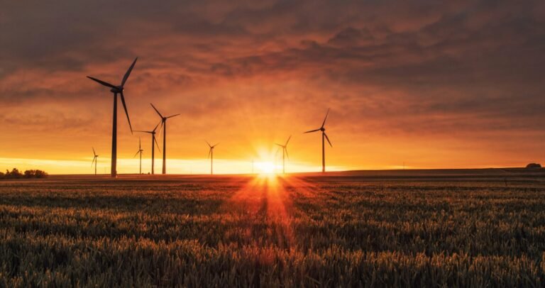A beautiful sunset with wind generating windmills silhouetted against the orange sky